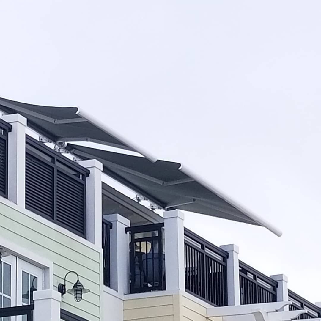 A building with a balcony and an awning on top of it.
