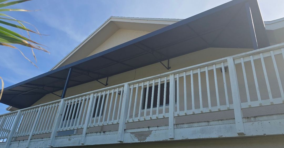 A house with a balcony and a canopy over it.