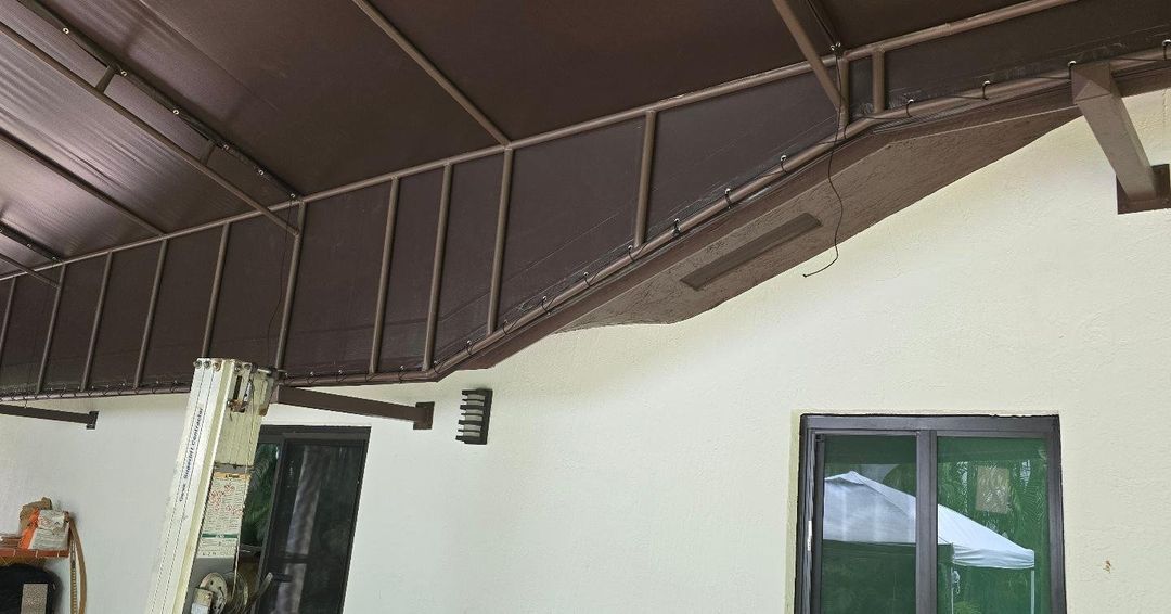 A white house with a brown roof and a window.