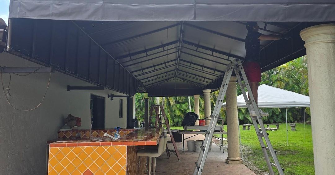 A man is standing on a ladder under a tent.