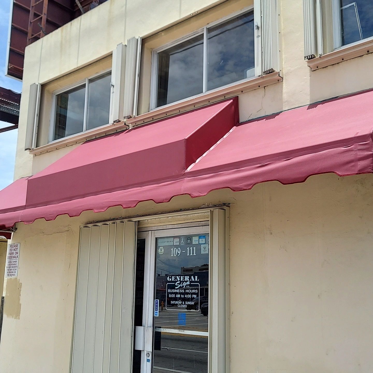 A store front with a pink awning over the door