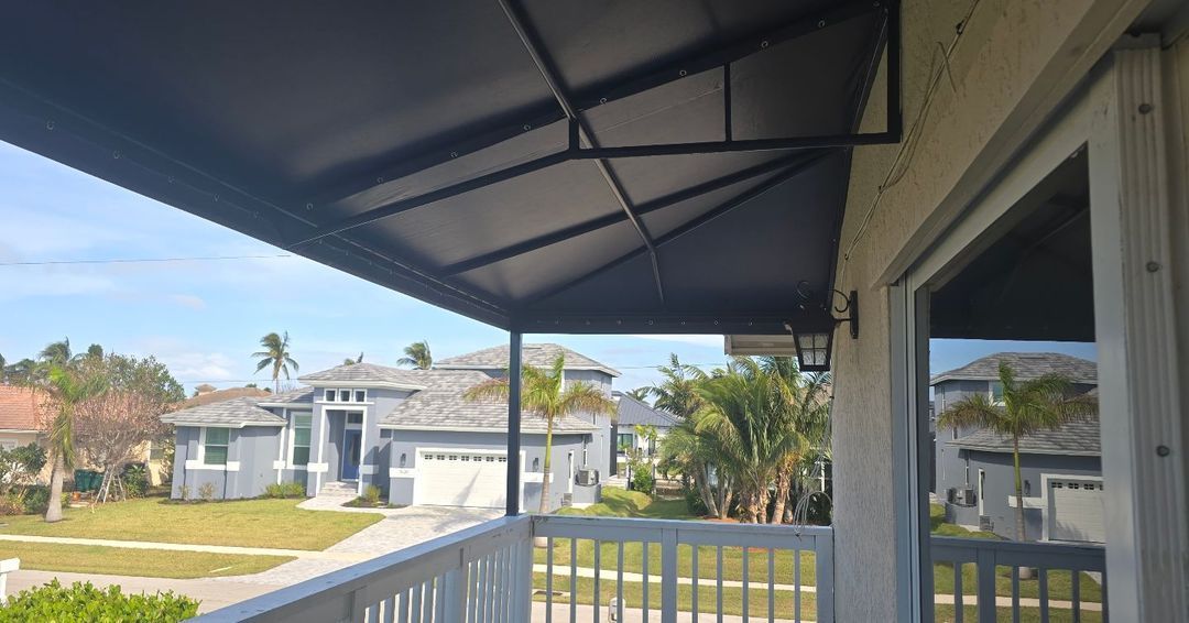 A balcony with a canopy over it and a view of a house.
