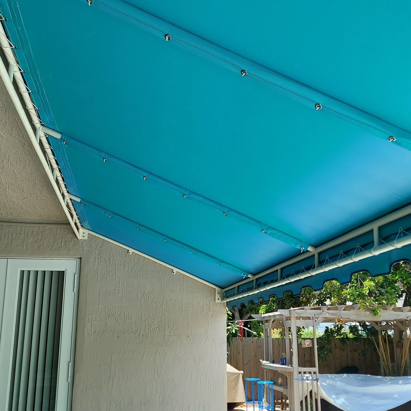 A blue awning is on the side of a house