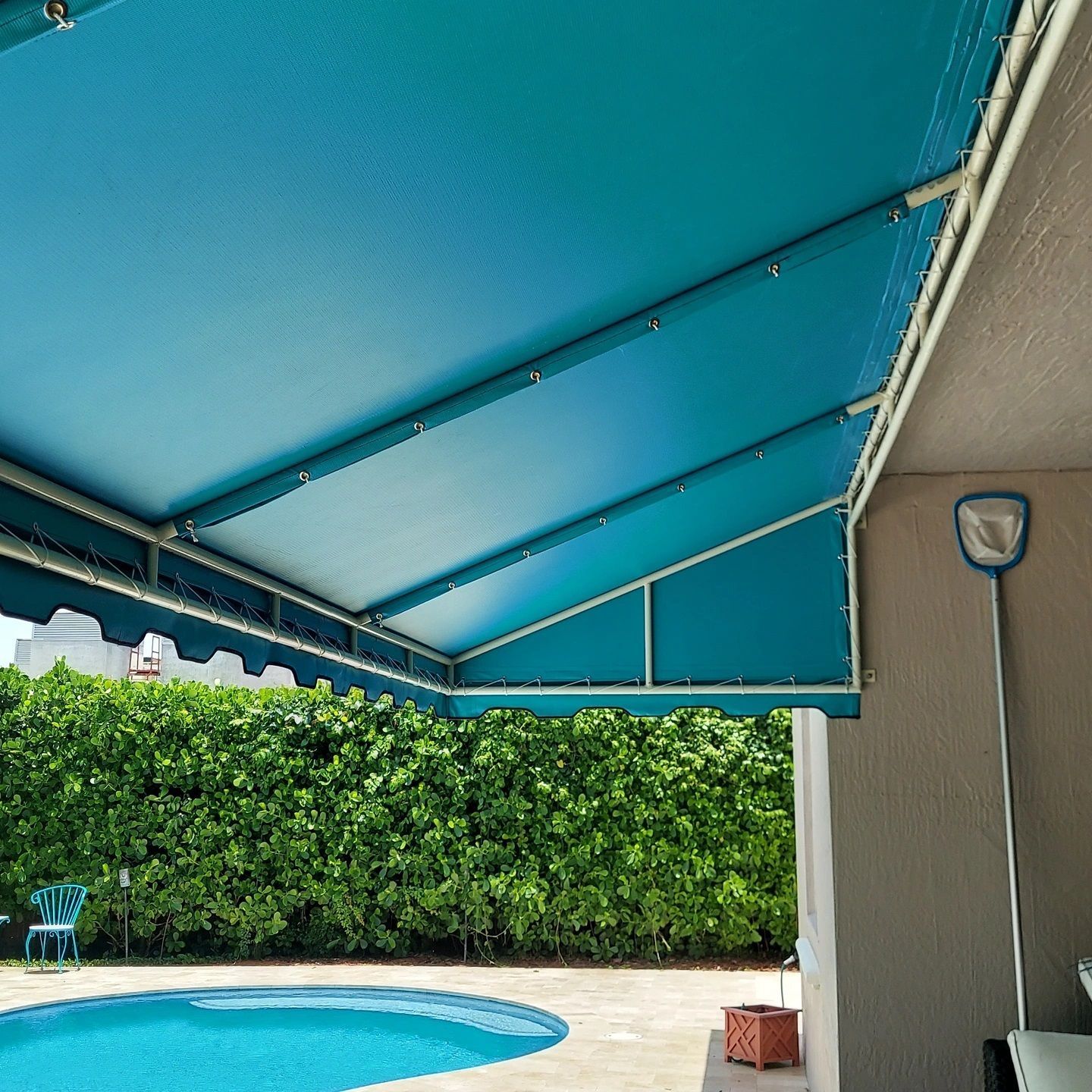 A swimming pool with a blue awning over it