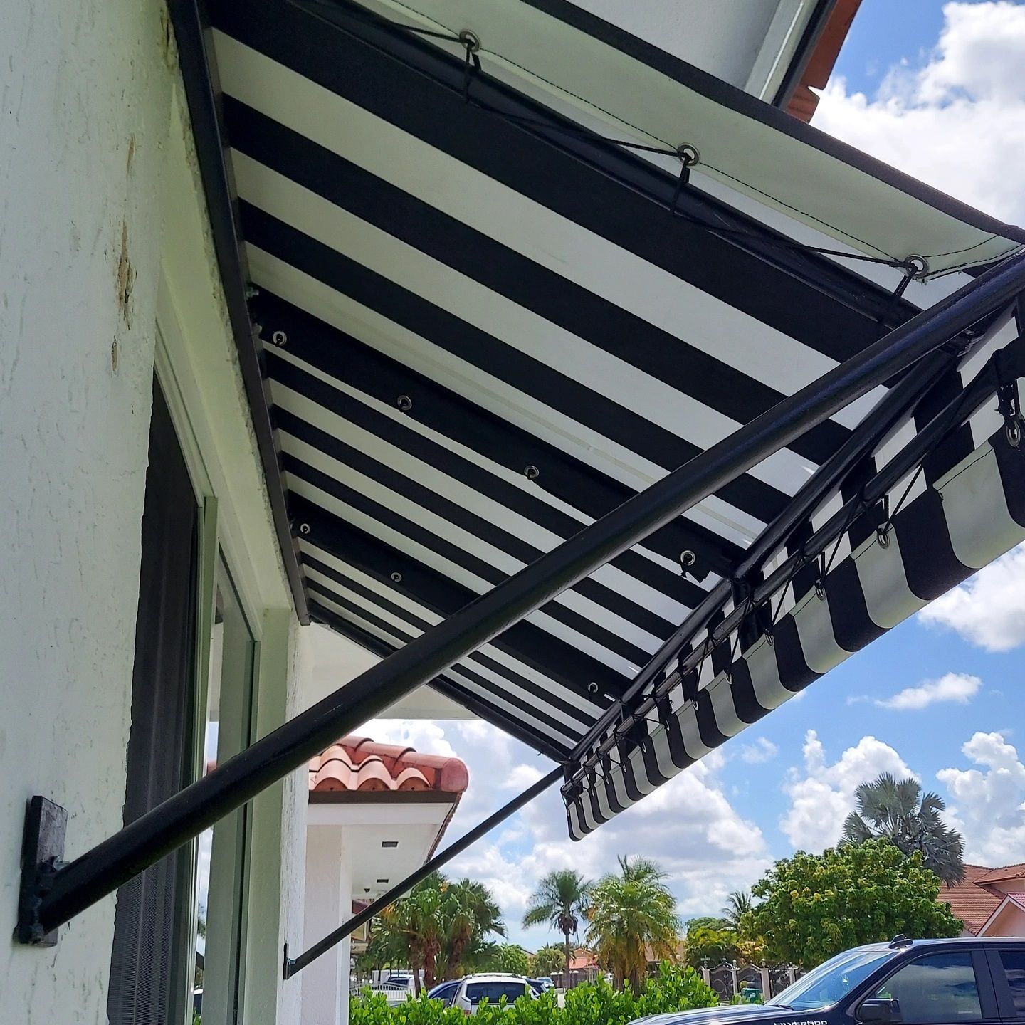 A black and white striped awning is hanging from the side of a building.