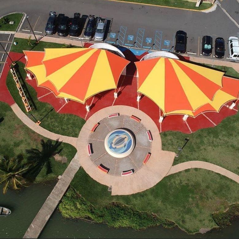 An aerial view of a park with orange and yellow umbrellas