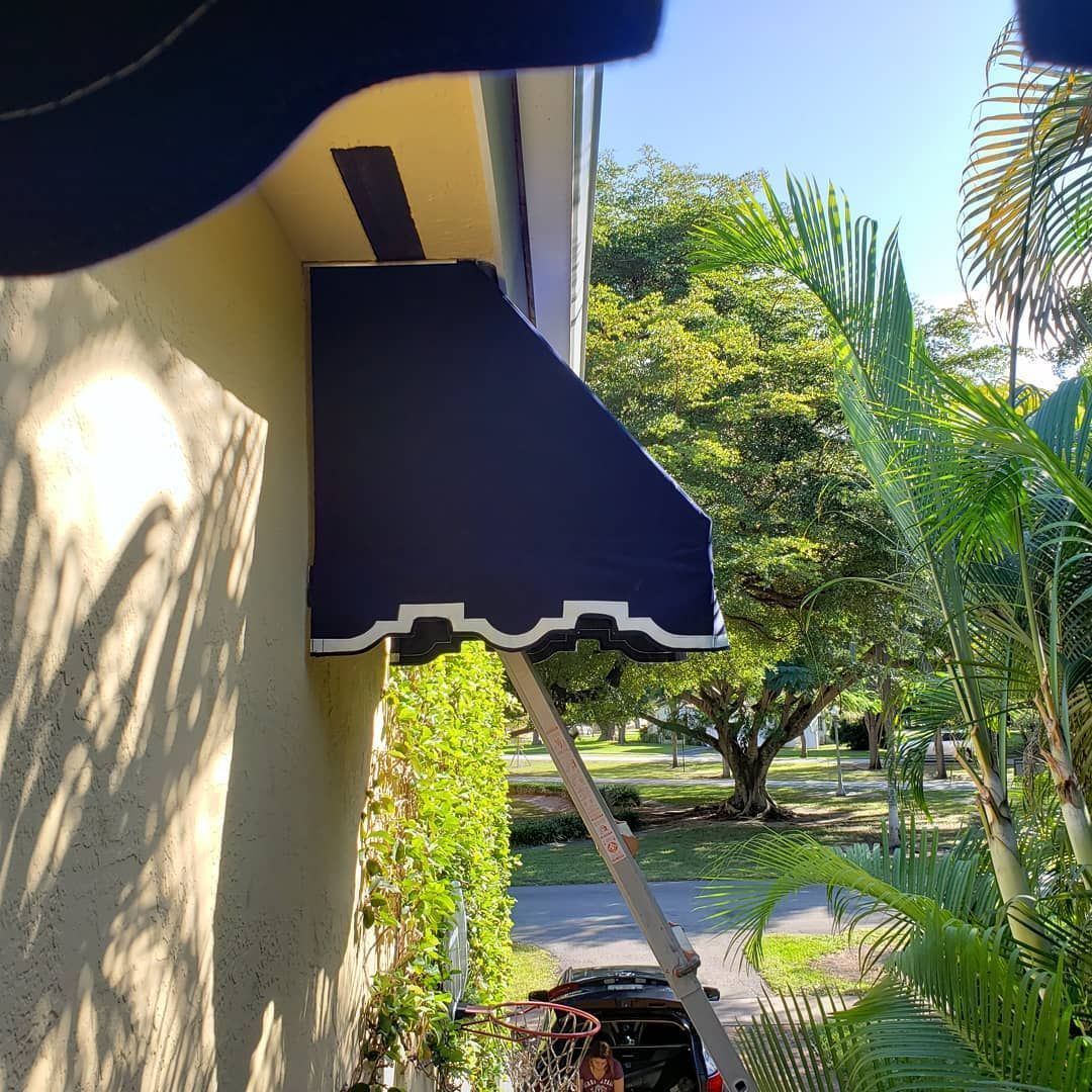 A blue awning is on the side of a building.