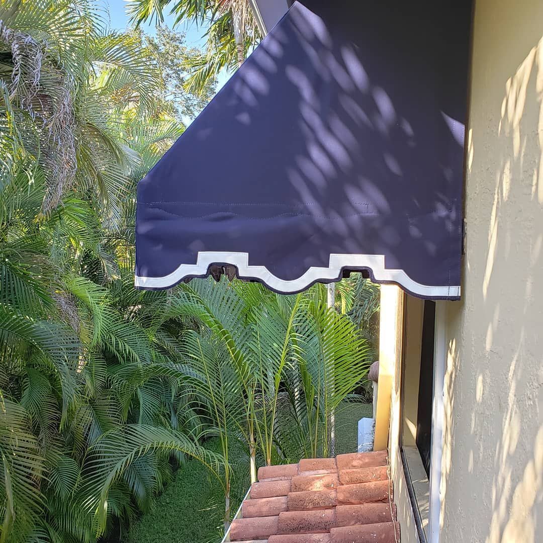 A blue awning is hanging from the side of a building.