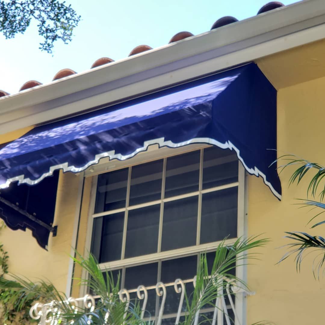 A yellow building with a blue awning over a window
