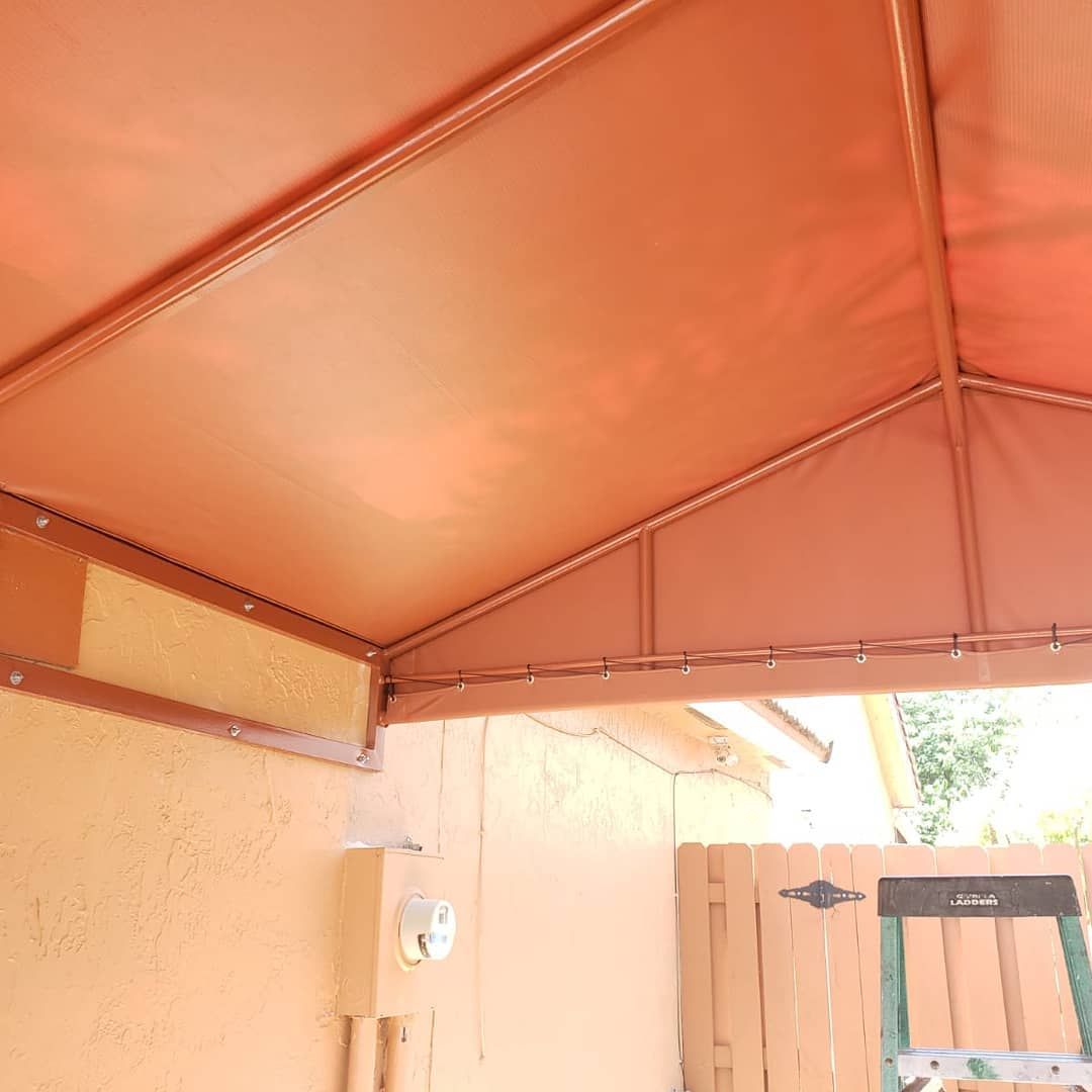 A brown awning is hanging over a wooden fence