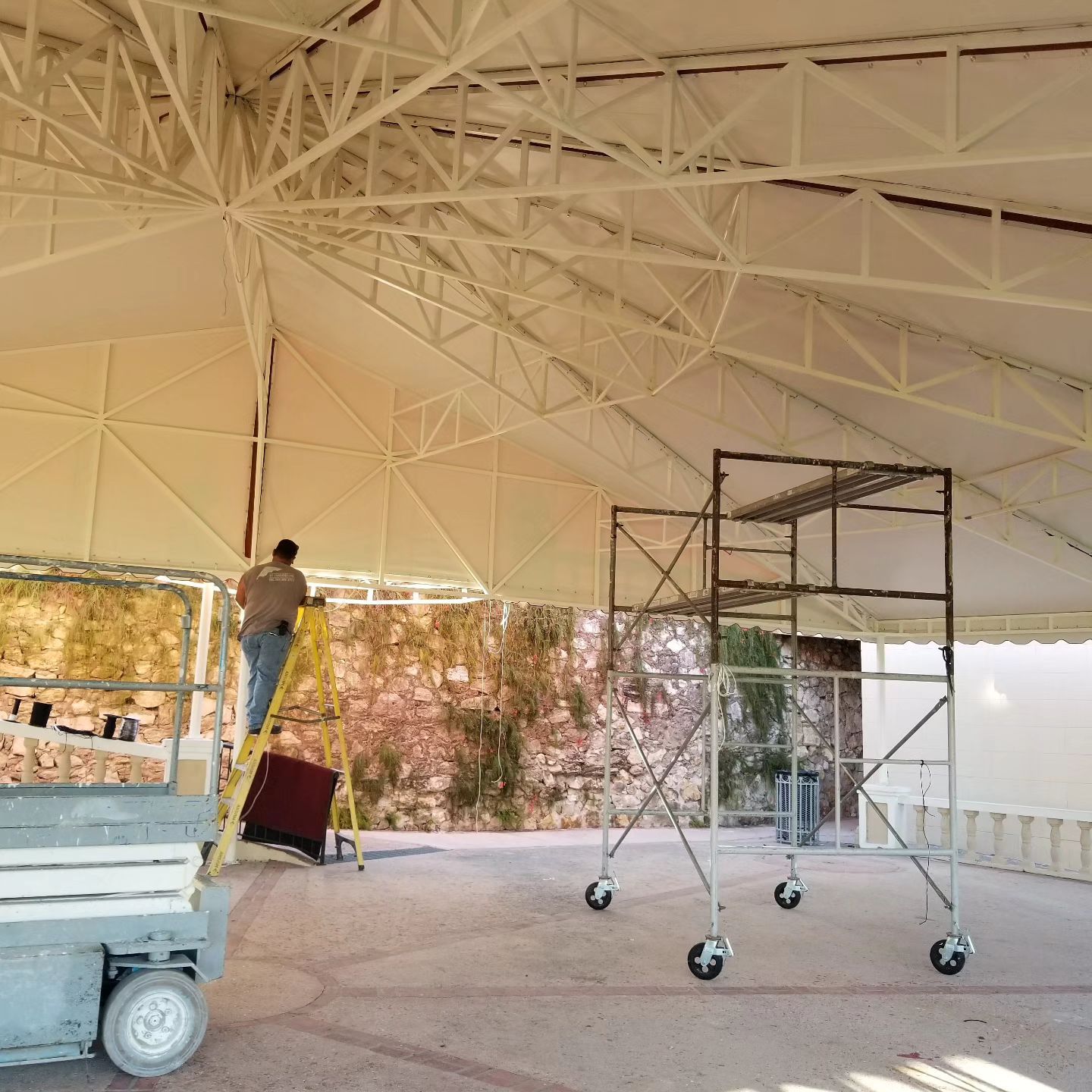 A man standing on a ladder under a tent