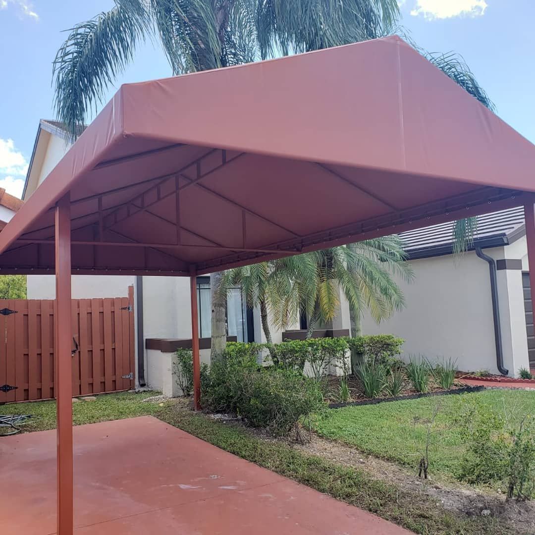 A red canopy is sitting in front of a house.