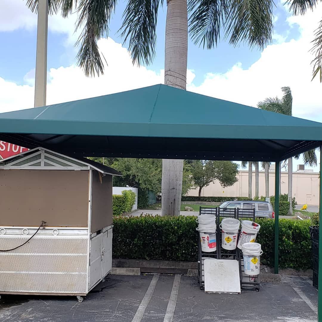 A canopy in a parking lot with buckets on display underneath it