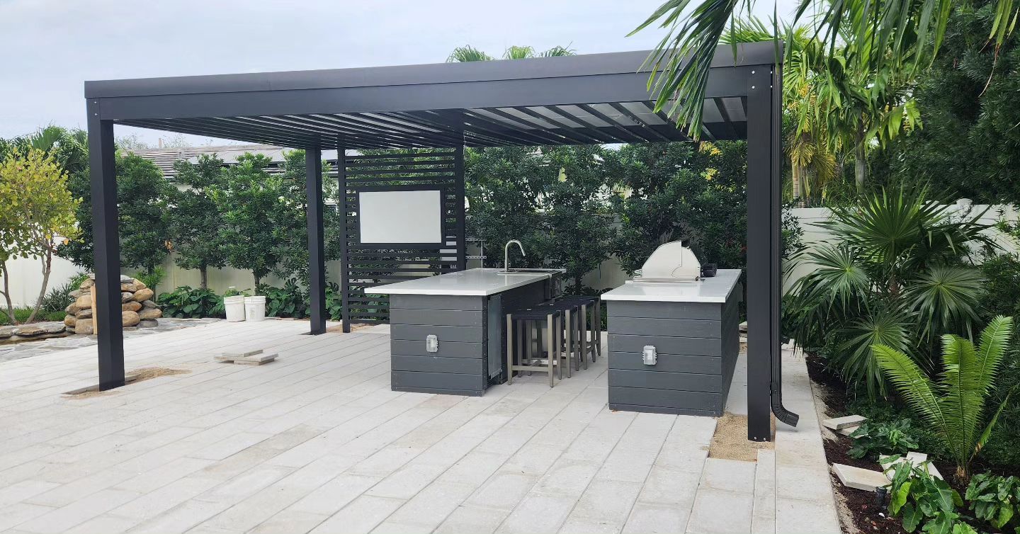 A patio with a pergola and a kitchen in the backyard.