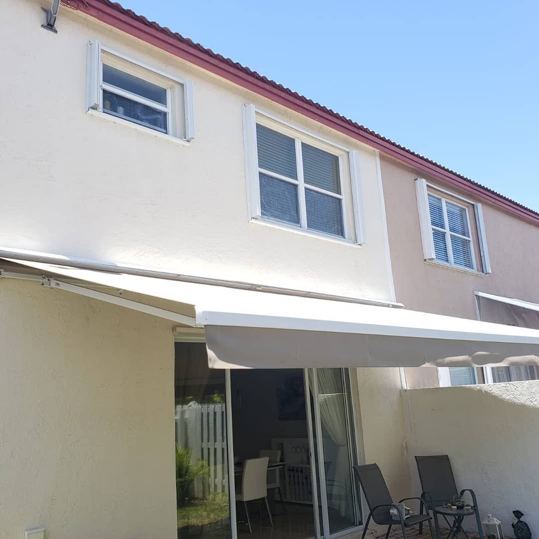 A house with a white awning on the side of it.