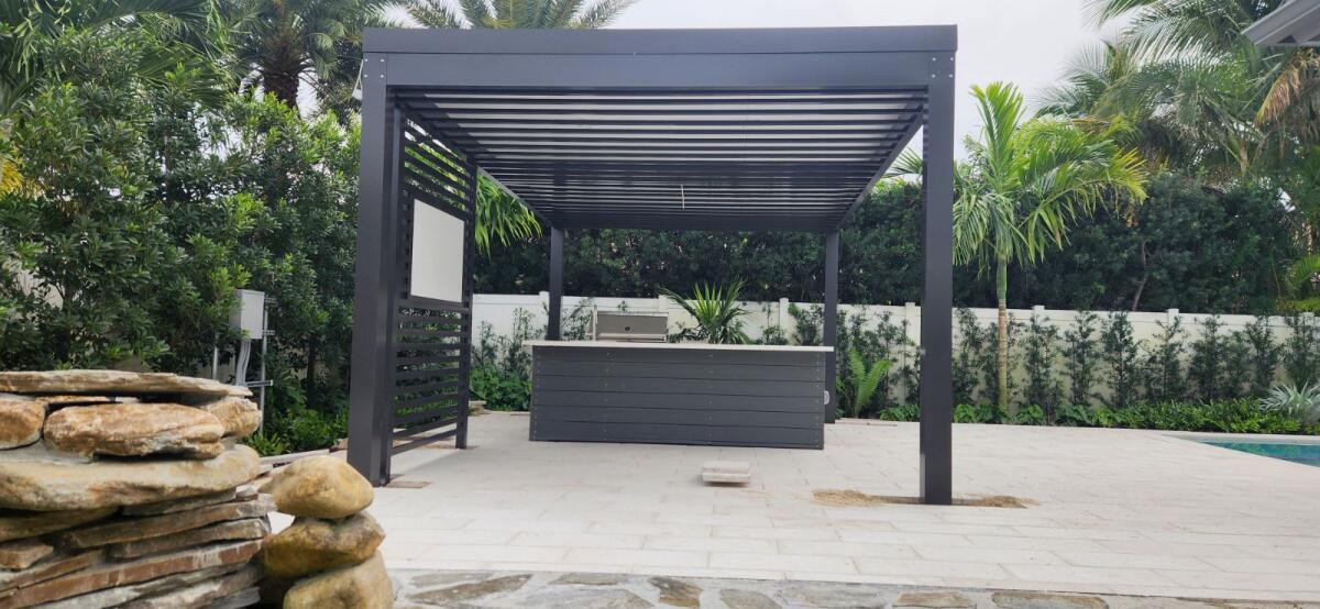 A pergola is sitting on top of a patio next to a pool.