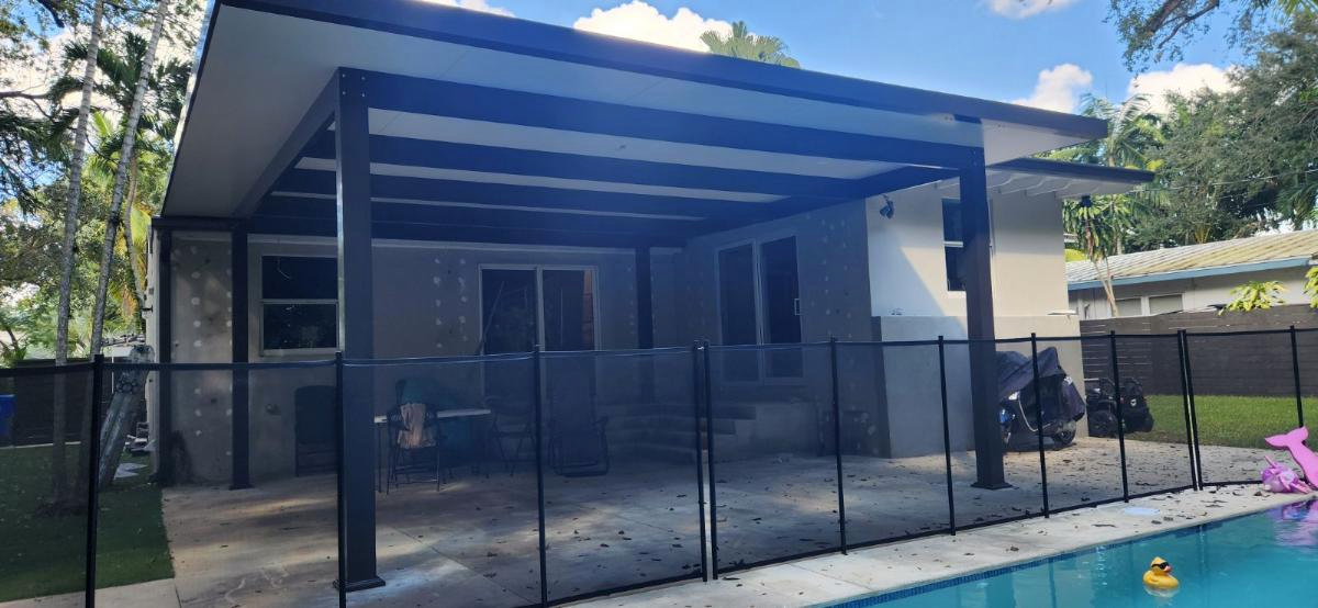 A house with a screened in porch and a pool.