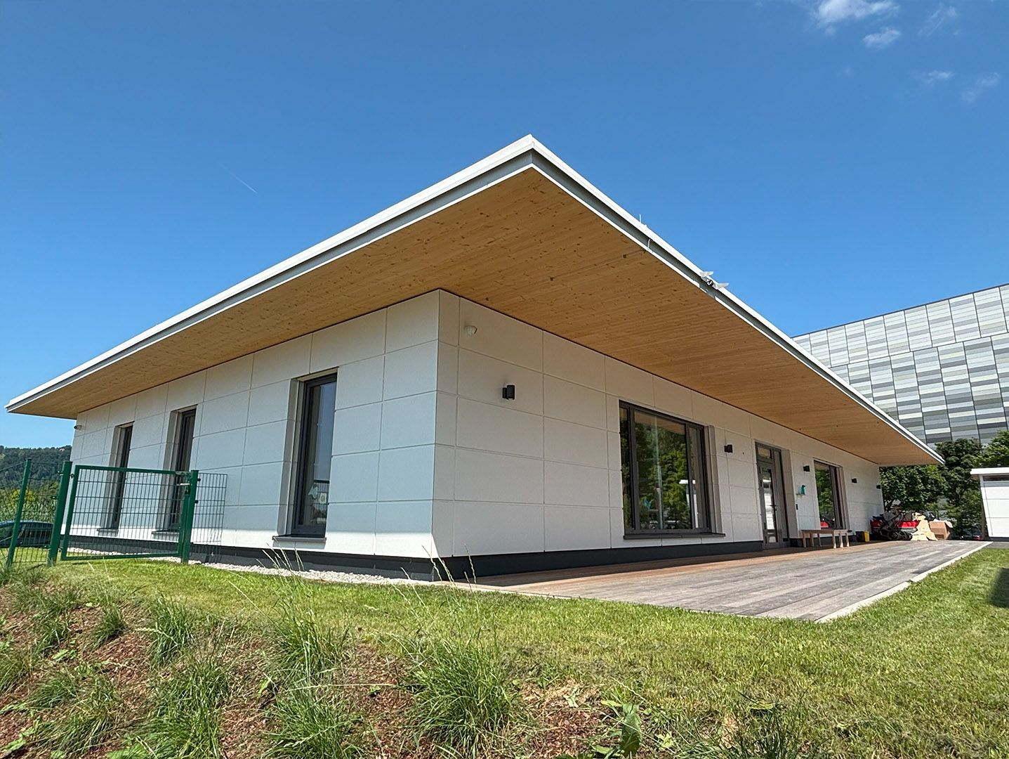 Ein weißes Haus mit einem Holzdach und vielen Fenstern