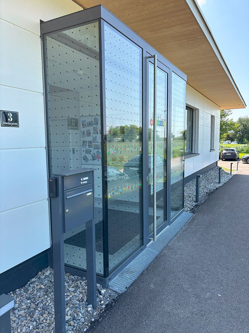 Der Eingang zu einem Gebäude mit vielen Glastüren.