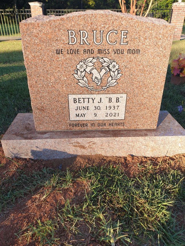 A gravestone for bruce betty j. b. is in a cemetery.