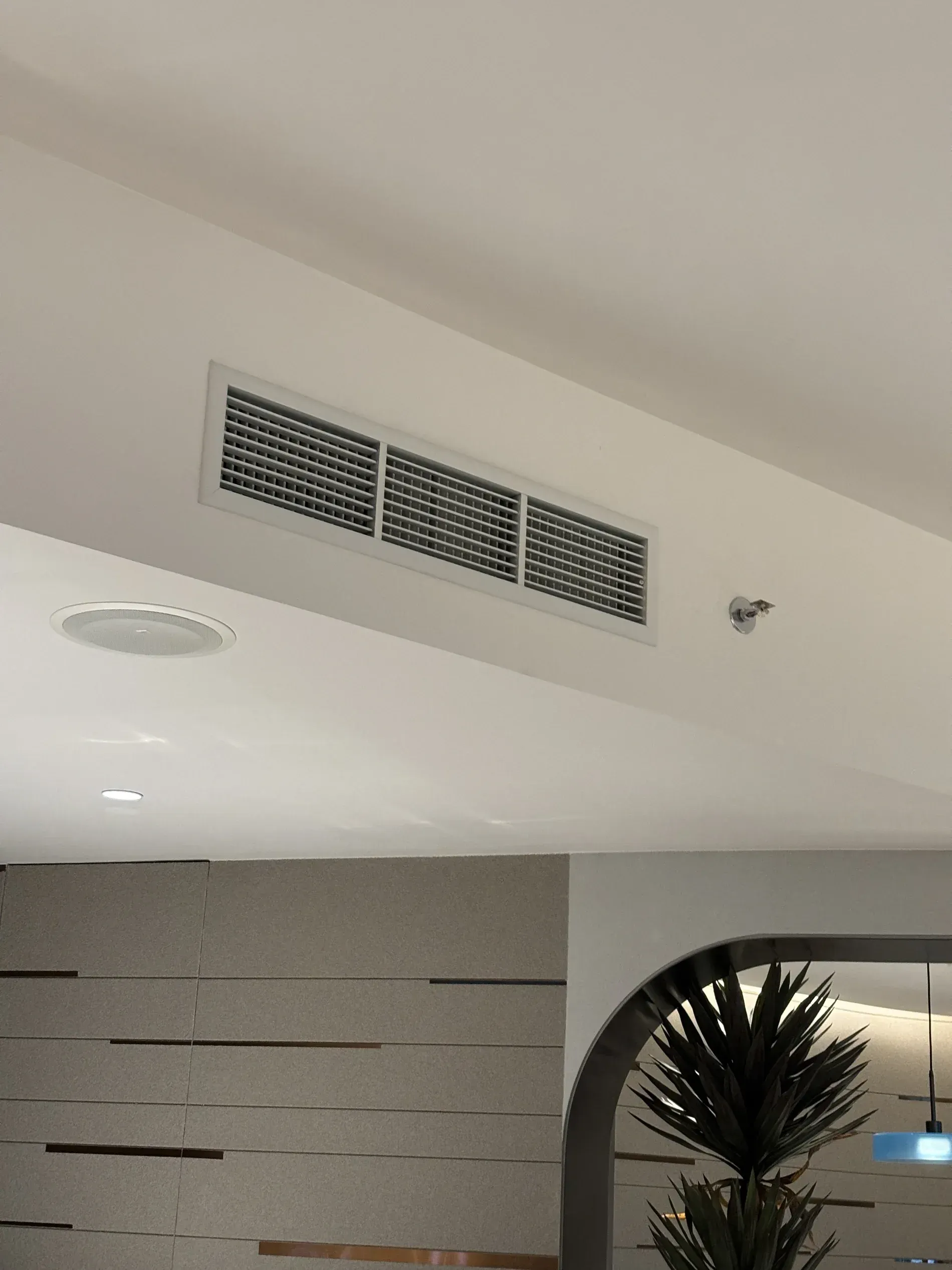 A Rectangular White HVAC Ceiling Vent with A Dark Grid on A White Wall — JF Air Conditioning Pty Ltd in Lake Macquarie, NSW