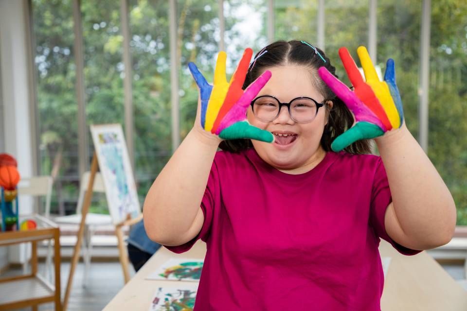Young girl painting colourful on hand for creative and learning arts