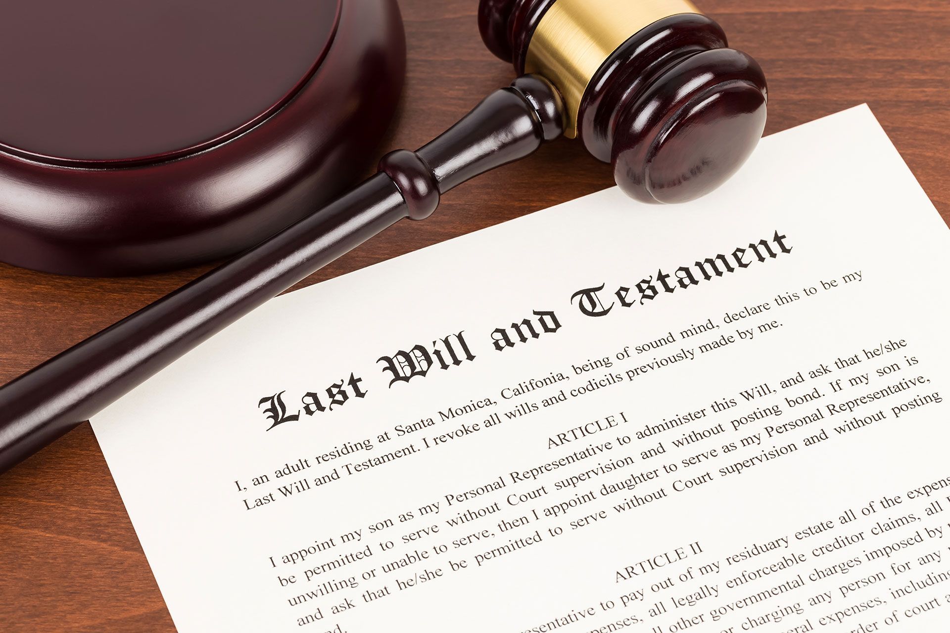 Last will and testament on yellowish paper with wooden judge gavel; document is mock-up