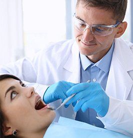 Periodontal Disease — Dentist Examining Patient's Teeth in Kalamazoo, MI