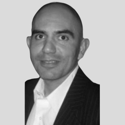 A man in a suit and tie is smiling in a black and white photo