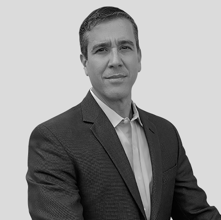 A man in a suit and tie is posing for a black and white photo.