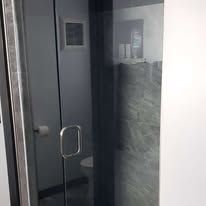 A bathroom with a glass door and a toilet.