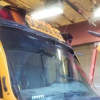 A yellow school bus is parked in a garage.