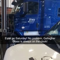 A blue truck is parked next to a white car in a garage.