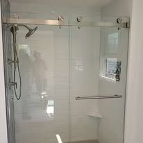 A bathroom with a sliding glass shower door and a shower head.