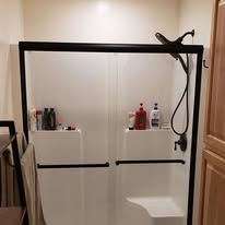 A bathroom with a sliding glass shower door and a shower head.