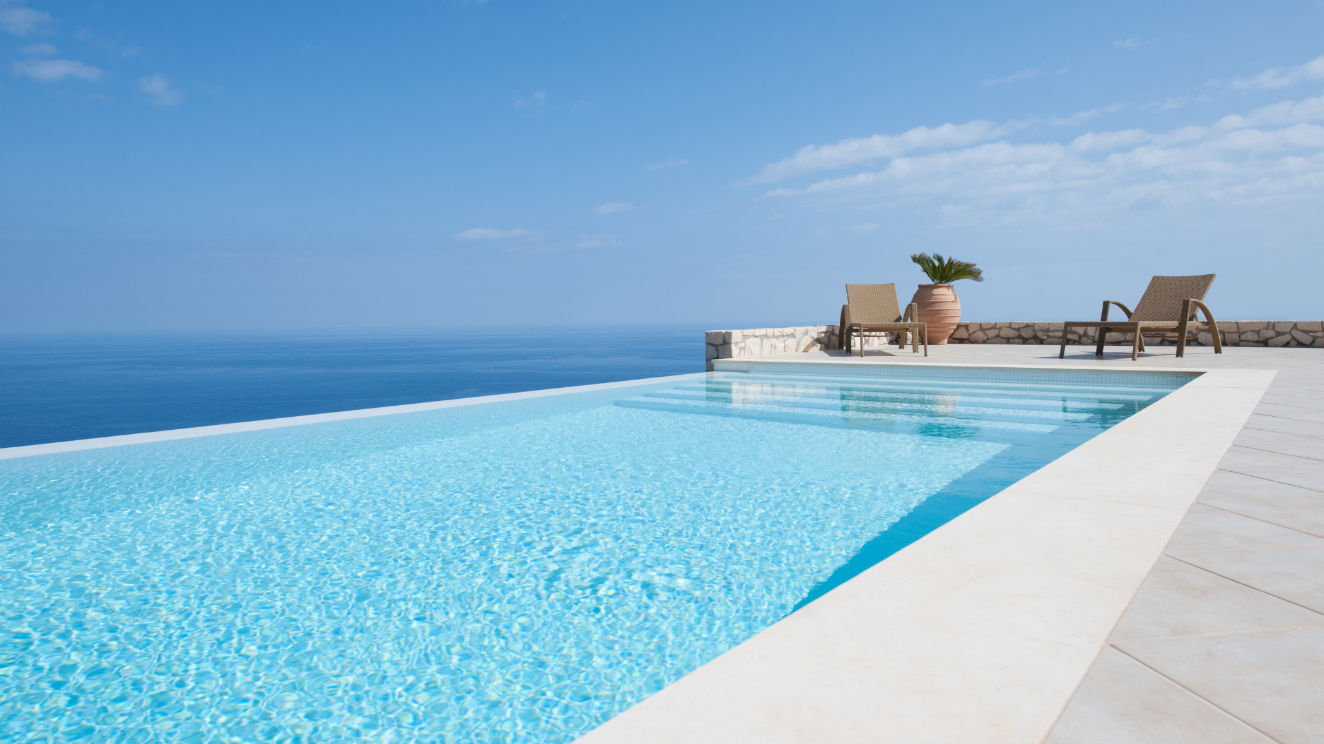 There is a swimming pool with a view of the ocean.