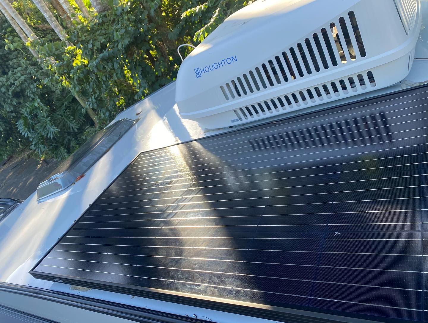 A Caravan With Solar Panels on the Roof is Parked on a Dirt Road — Activate Auto Electrics & Air Conditioning In Caloundra, QLD