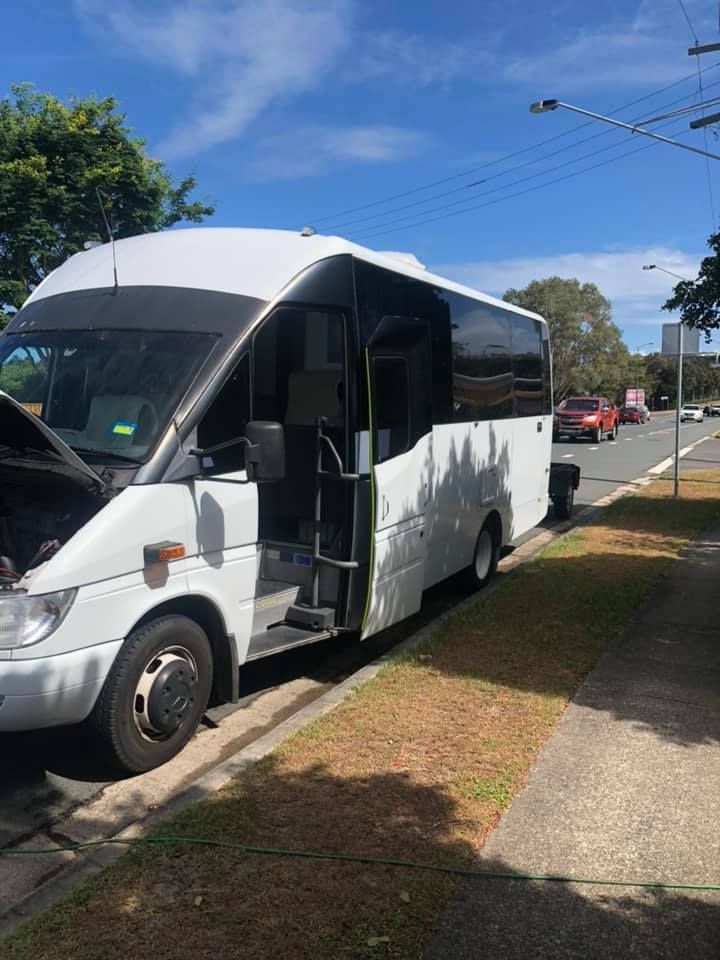 A White Bus is Parked on the Side of the Road — Activate Auto Electrics & Air Conditioning In Caloundra, QLD
