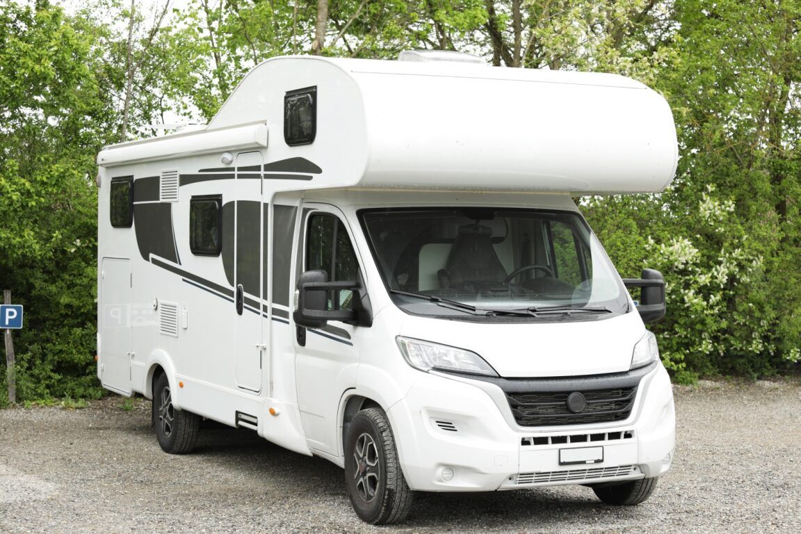A White Rv is Parked in a Gravel Lot — Activate Auto Electrics & Air Conditioning In Caloundra, QLD