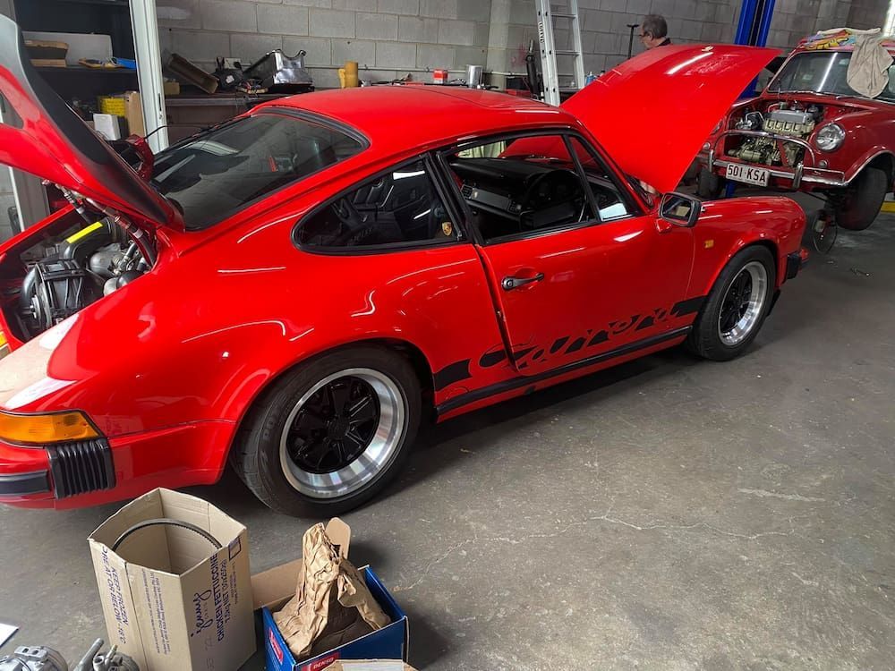 A Red Porsche is Parked in a Garage With Its Hood Up — Activate Auto Electrics & Air Conditioning In Caloundra, QLD