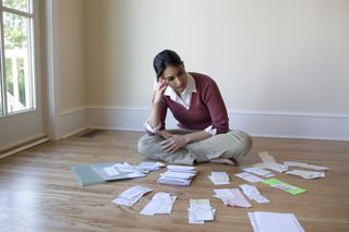 Tax Debt — Woman Looking at Bills on the Floor in Aiken, SC