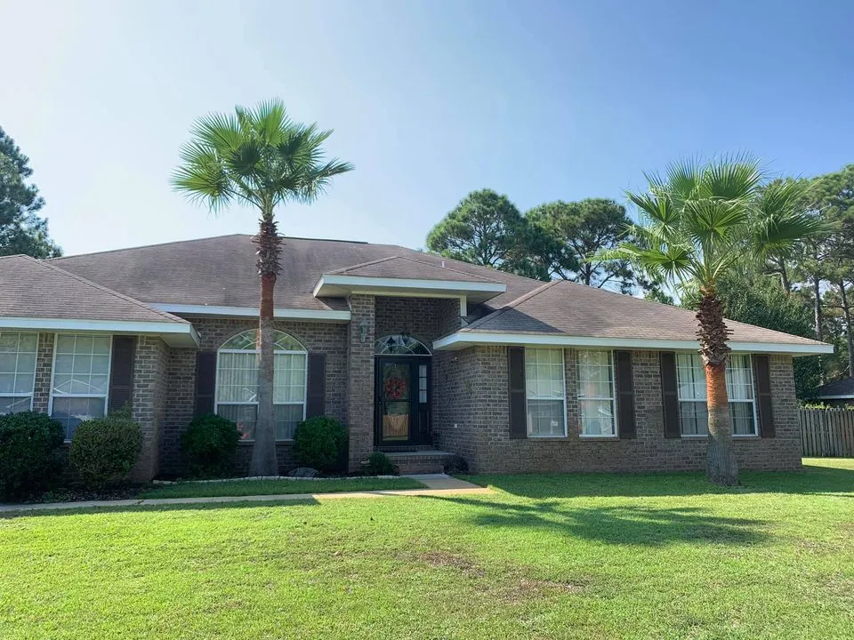 A brick house with two palm trees in front of it