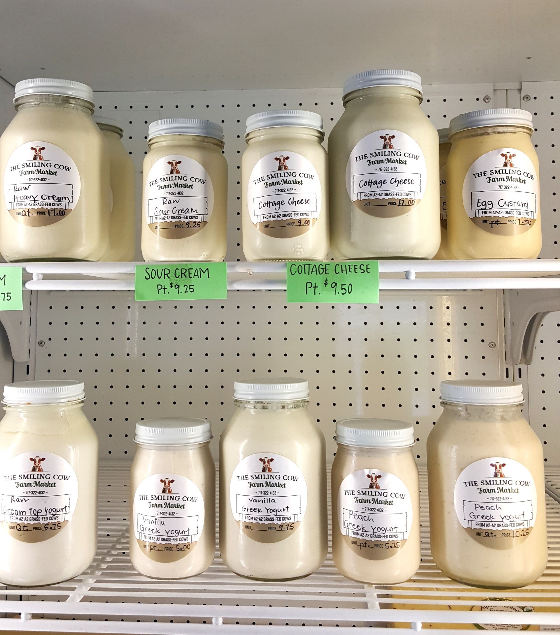 Several jars of yogurt are lined up on a shelf