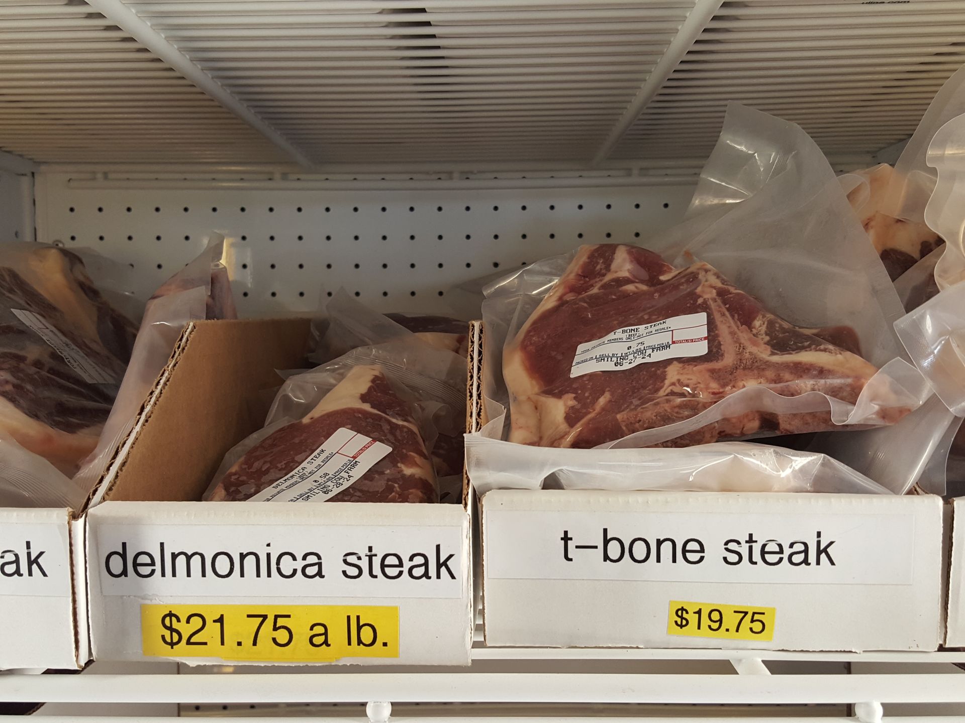 Boxes of delmonica steak and t-bone steak in a refrigerator