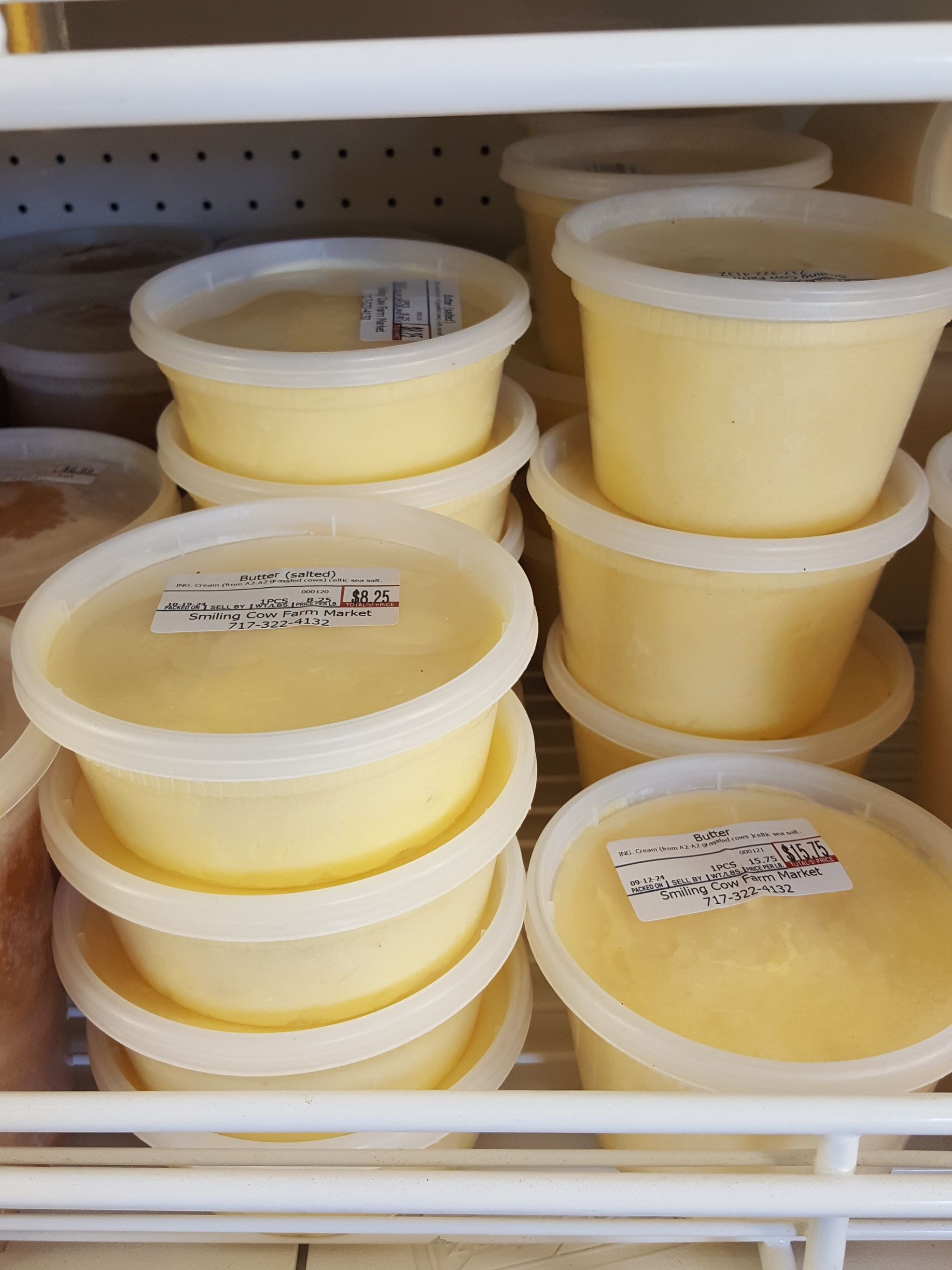 A shelf full of plastic cups filled with yellow liquid.