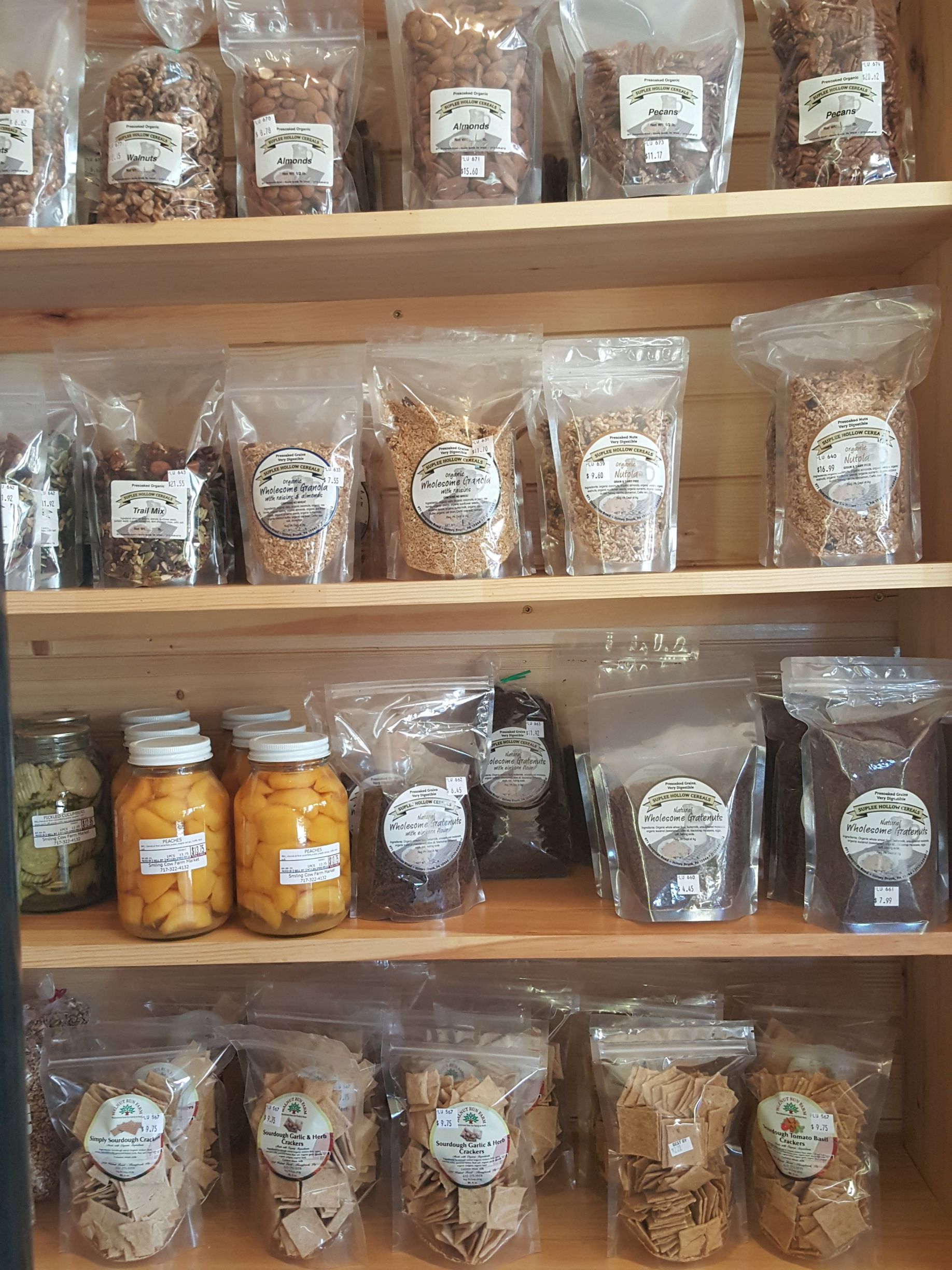 A shelf filled with bags of food and jars of pickles.