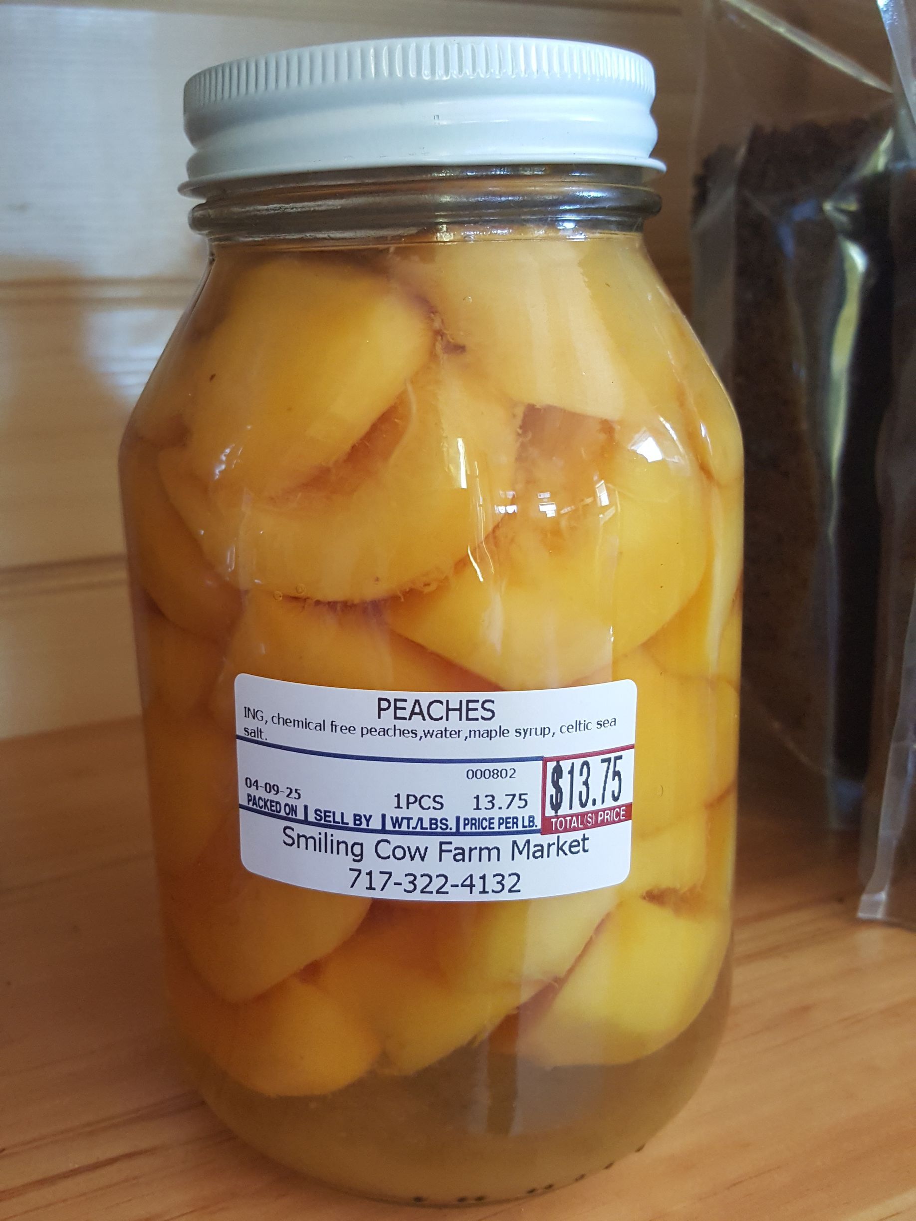 A jar of canned peaches from The Smiling Cow Farm Market