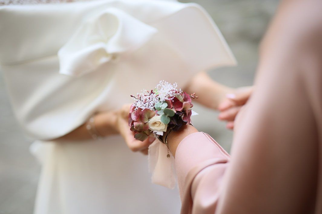 una donna tiene al polso un mazzo di fiori.