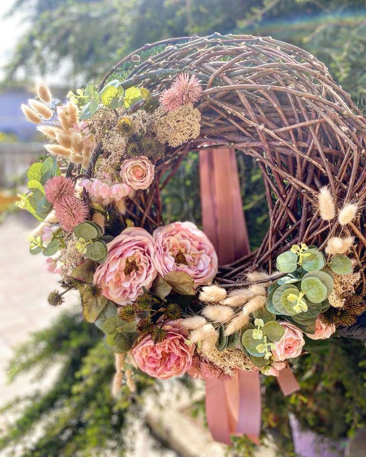 una ghirlanda con fiori rosa e un nastro rosa.