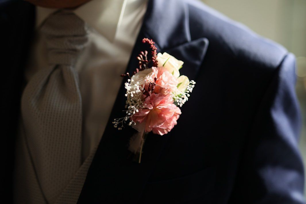 un uomo in abito con fiori rosa e bianchi